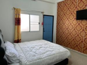 a bedroom with a white bed and a window at SB Hotel in Betong +8 photos
