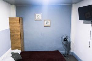 a bedroom with a blue wall and a fan at Coliving La Rebeca Pereira in Pereira
