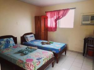 a room with two twin beds and a window at Bee Hub Pension in Surigao