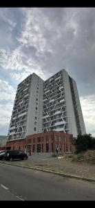 un grande edificio bianco con un edificio in mattoni rossi di My Sweet Home in Rustavi City 14 a Rustavi