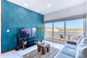 ein Wohnzimmer mit Sofa und Fernseher in der Unterkunft Fragata 404 in Cabo San Lucas