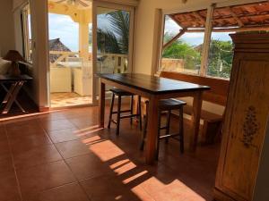a dining room with a table and chairs and a window at En el Mar in Nueva Gorgona
