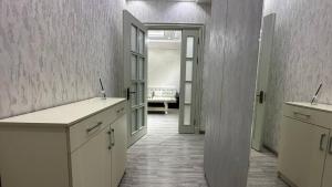 een keuken met witte kasten en een open deur bij Parkent luxe 261 in Tasjkent