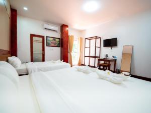 Postel nebo postele na pokoji v ubytování Vientiane Ruby Villa Hotel