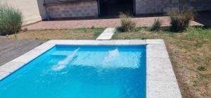 a swimming pool with blue water in a yard at Casa Alisos Grande in El Ceibal +5 photos