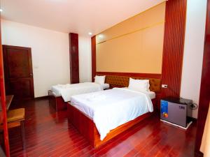 Postel nebo postele na pokoji v ubytování Vientiane Ruby Villa Hotel