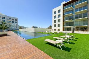 Eine Gruppe von Liegestühlen auf der Wiese neben einem Gebäude in der Unterkunft Fragata 404 in Cabo San Lucas