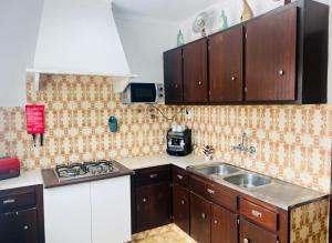 a kitchen with wooden cabinets and a sink at Lugar de Passos in Sesimbra
