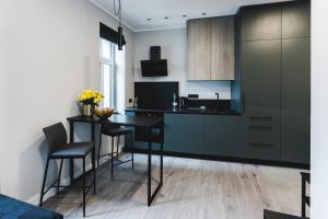 a kitchen with a black table and some chairs at Dzirnavu Apartment in Riga