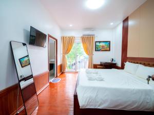 Postel nebo postele na pokoji v ubytování Vientiane Ruby Villa Hotel