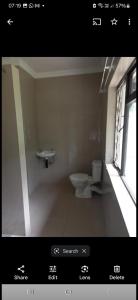 a bathroom with a toilet and a window at Lubo house in Pinetown