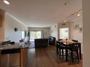 a kitchen and living room with a table and chairs at SoCal Lux on Miramar in Los Angeles