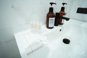 tre bottiglie di alcol sul lavandino del bagno di Gonzales Hotel a Cauayan