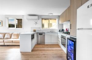a kitchen with white cabinets and a couch at Metres from the Beach, Outdoor Area, Spacious in Ocean Grove +30 photos