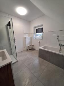 un bagno con vasca, WC e lavandino di Murtal Appartement Größingblick Top 5 a Zeltweg
