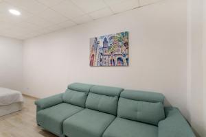 a green couch in a room with a painting on the wall at Eva García Naranjo in Las Palmas de Gran Canaria