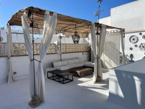 a patio with a couch under a canopy at Mina25 by 7Escalones in Rota