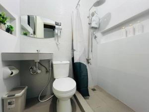a white bathroom with a toilet and a sink at Rej Homestay in Lipa