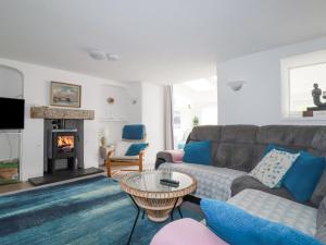 a living room with a couch and a fireplace at Langurra in Newquay