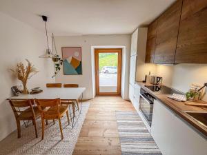a kitchen and dining room with a table and chairs at Chasa Savü in Guarda