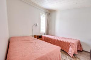 two beds in a white room with a window at Holiday Apartment Skivillas 26 B 9 in Ukkohalla +8 photos