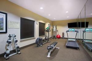 a gym with several tread machines and a flat screen tv at La Quinta by Wyndham Pearsall in Pearsall
