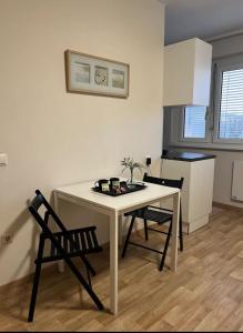 a white table and chairs in a room with a kitchen at Charmante Wohnung im Herzen von Graz in Graz