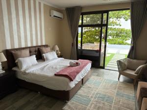 SomveBaobab Beach Villa Mangochi的一间卧室设有一张大床和一个滑动玻璃门