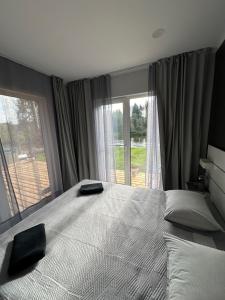 a bedroom with a large bed with a large window at Kempings Jaunzāģeri "Pietura" in Sigulda