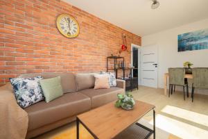a living room with a couch and a brick wall at Exceptional Apartment in Warsaw with Parking by Noclegi Renters in Warsaw +12 photos