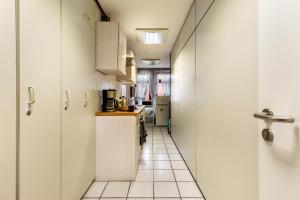 a kitchen with white cabinets and a tile floor at Relax Backnang Apartment in Backnang