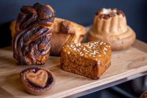 a wooden tray with different types of bread and pastries at Hotel La Diligence in Obernai