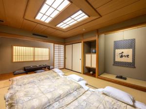 a bedroom with a large bed and a skylight at Tsubamesanjo Washington Hotel in Sanjo +62 photos
