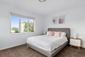 ein weißes Schlafzimmer mit einem Bett und einem Fenster in der Unterkunft Contemporary with Courtyard by Sandy Bay Delights in Sandy Bay