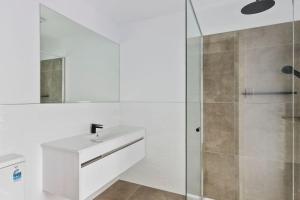 ein weißes Badezimmer mit Waschbecken und Dusche in der Unterkunft Contemporary with Courtyard by Sandy Bay Delights in Sandy Bay + 13 Fotos