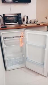 an open refrigerator in a kitchen with a microwave at Departamento - M I N I D O in Resistencia