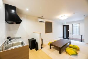 a kitchen with a sink and a table at Irodori Hotel KOU in Fukuoka