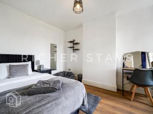a bedroom with a bed and a desk at Watford Large 5BR Home - Contractors & Families in Watford +11 photos