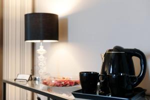 a table with a coffee pot and a lamp on it at Residenza Edoardo I in Rome