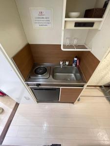 Una pequeña cocina con fregadero y estufa. en Kurarisu Hakata クラリス博多, en Fukuoka 108 fotos más