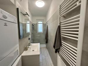 a white bathroom with a sink and a shower at La Casa Gialla di Valentina in Bellano +10 photos