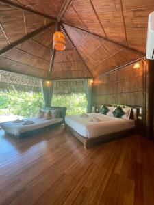 two beds in a room with a wooden floor at Villa Baan Pak Pra in Ban Pak Pra (1) +93 photos