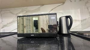 een magnetron op het aanrecht naast een kopje bij Parkent luxe 261 in Tasjkent