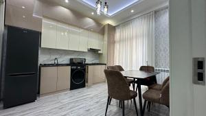een keuken met een tafel en stoelen in een kamer bij Parkent luxe 261 in Tasjkent