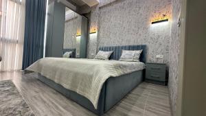 een slaapkamer met een bed met een blauw hoofdeinde bij Parkent luxe 261 in Tasjkent