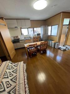 a living room with a table and chairs and a kitchen at 一棟貸切ゲストハウス in Enoura
