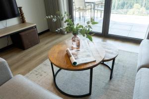 a living room with a table with a vase on it at Astenblick Apartments Winterberg with sauna in Winterberg +74 photos
