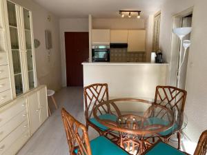 a dining room with a table and chairs and a kitchen at C219 -2 pieces avec parking proche plage in Arcachon +6 photos