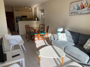a living room with a couch and a table and chairs at C219 -2 pieces avec parking proche plage in Arcachon