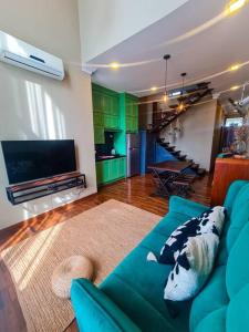 a living room with a blue couch and a kitchen at Premium Vintage Home 2 Master Bedrooms 2 to 4 Pax Comfy Stay for Friends and Family in Cyberjaya